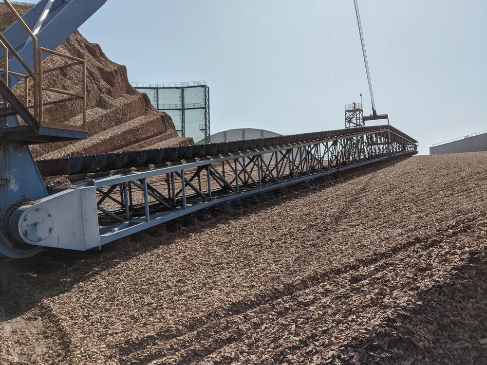 Stacker building a bulk stockpile at a materials handling facility