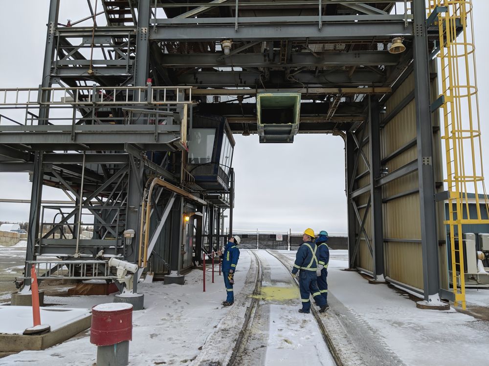Field crew reviewing work at a rail loadout structure in winter